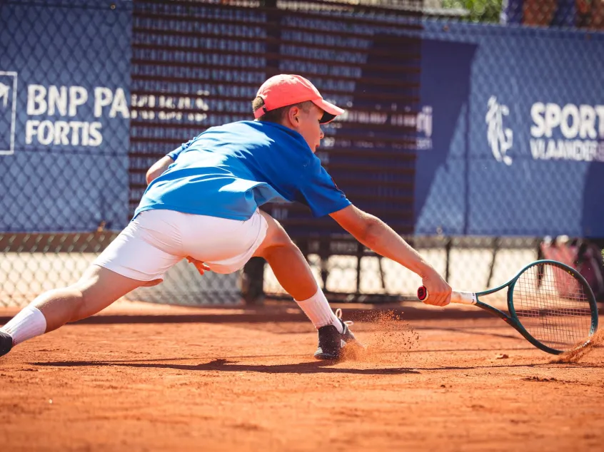 A tennis player slides to hit